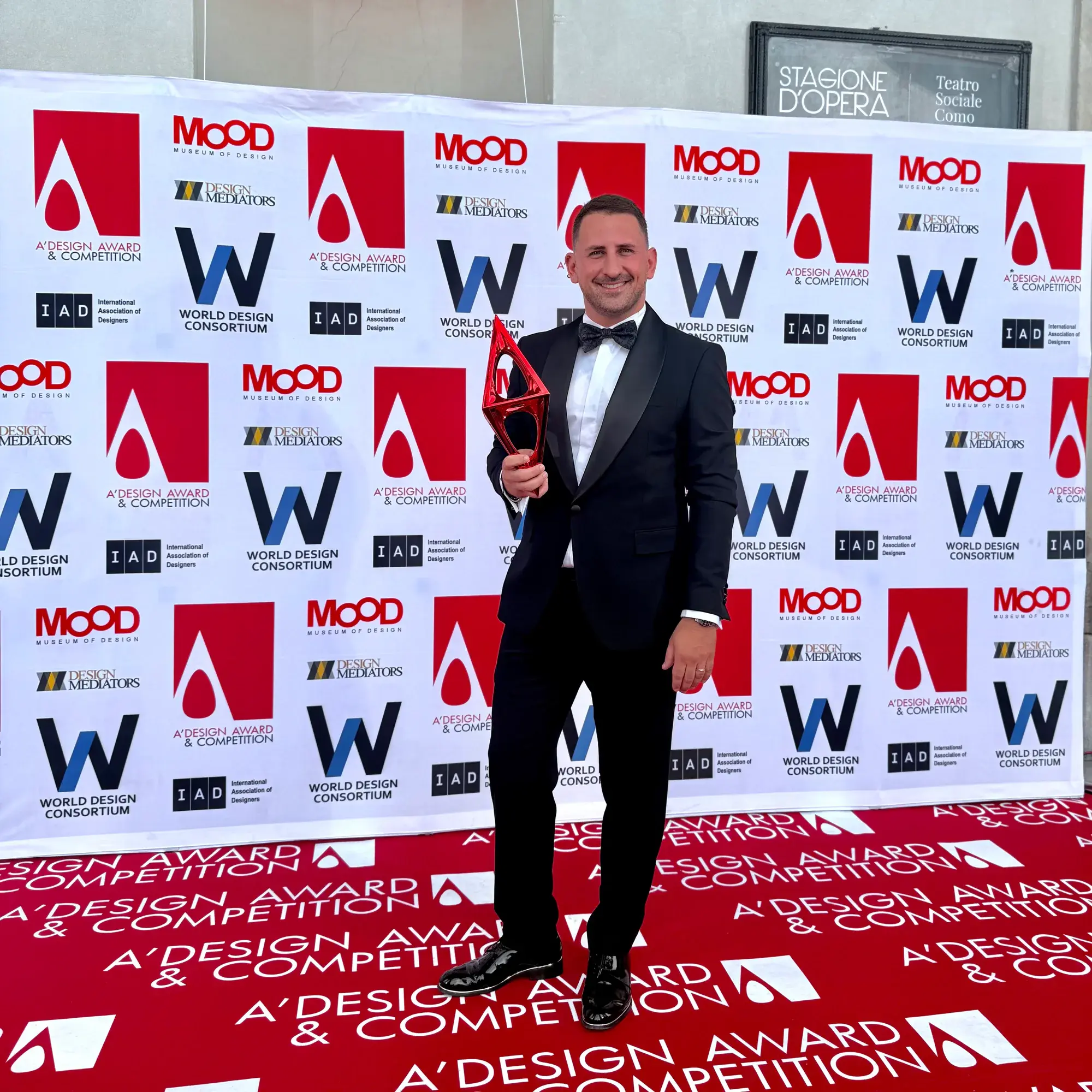 A Why Agency collaborator holding a design award
