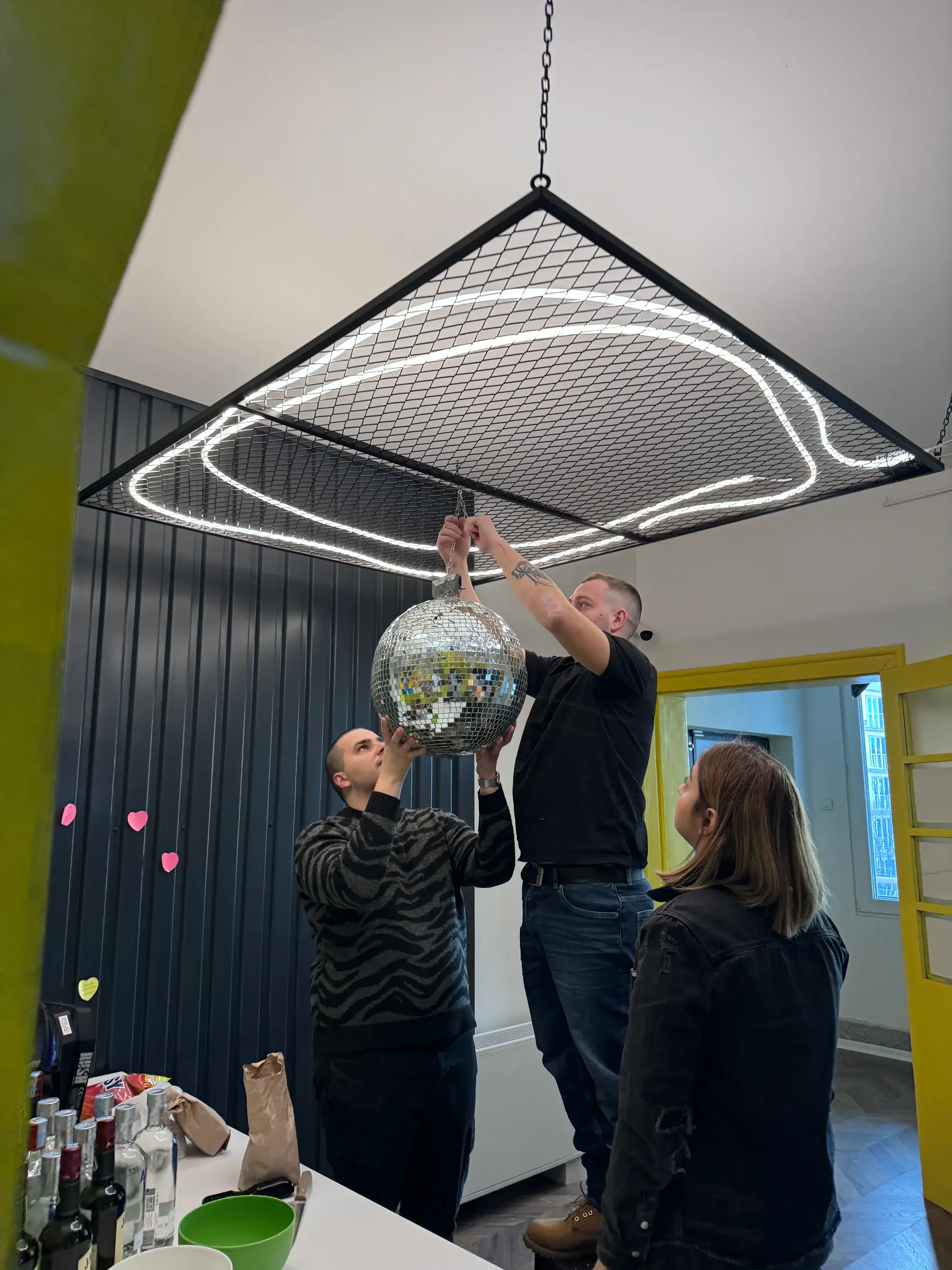 Why Agency team members installing a disco ball in the studio